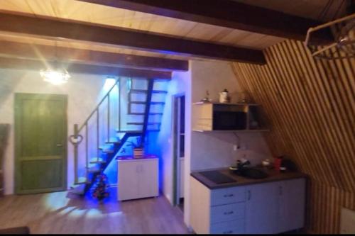 une cuisine avec un escalier bleu dans une pièce dans l'établissement Cabana Vânătorilor A Frame Green, à Văliug