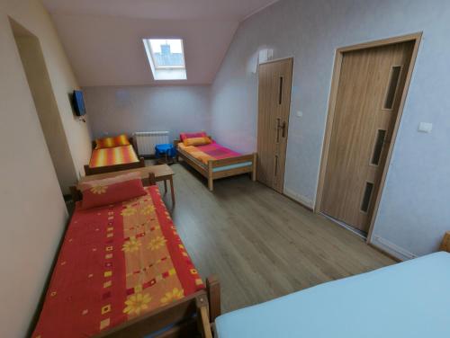 a small room with two beds and a window at Pokoje Gościnne "U Karola" Pracownicze in Ścinawa