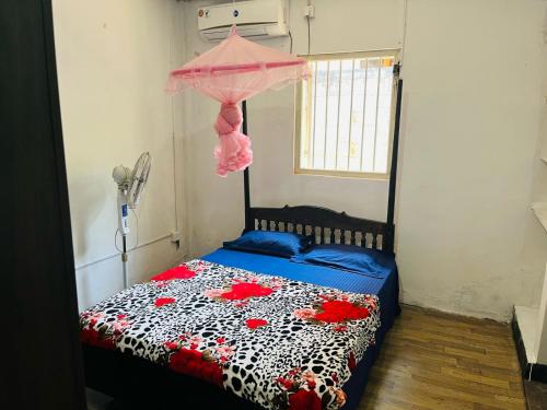 een slaapkamer met een bed met een roze paraplu bij AUD Home Stay 