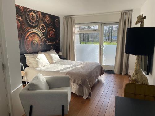 sypialnia z łóżkiem, krzesłem i oknem w obiekcie BnB Goldies w Eindhoven