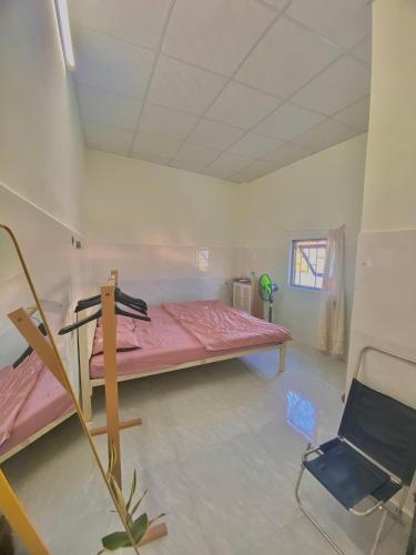 a room with a pink bed and a chair in it at Homestay Tuyết Trinh in Nha Trang