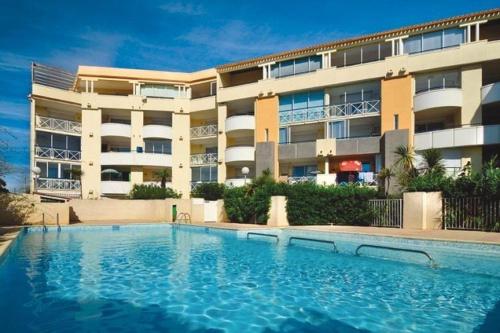 une grande piscine devant un immeuble dans l'établissement SAVANNA BEACH II Joli appartement 3 pièces avec piscine Rochelongue Cap d'Agde, au Cap d'Agde
