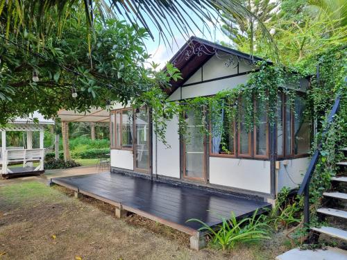 a tiny house with a porch and a staircase at Wind in the Wild Khao Yai in Nakhon Ratchasima