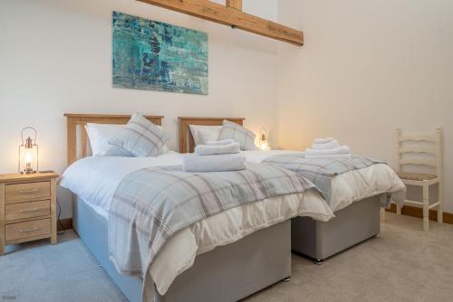 a bedroom with two beds and a chair in it at Hafod-Llecheiddior in Brynkir