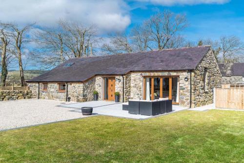 a stone house with a large yard in front of it at Hafod-Llecheiddior in Brynkir