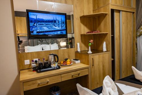 a room with a television on a wooden wall at Zowar International Hotel in Al Madinah