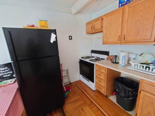 een keuken met een zwarte koelkast en een fornuis bij Spacious Room for 4 People in Williamsburg ! in Brooklyn