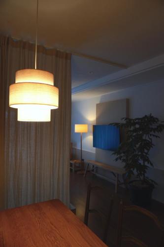 a dining room with a table and a light fixture at At corner resort & garden in Jeju