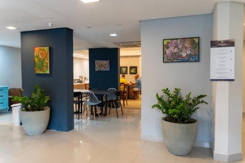 a lobby with two potted plants and a dining room at Dublê Hotel - The Original in Recife
