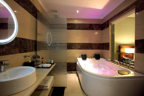 y baño con bañera y lavamanos. en Grand Plaza Hotel - Dhabab Riyadh, en Riad