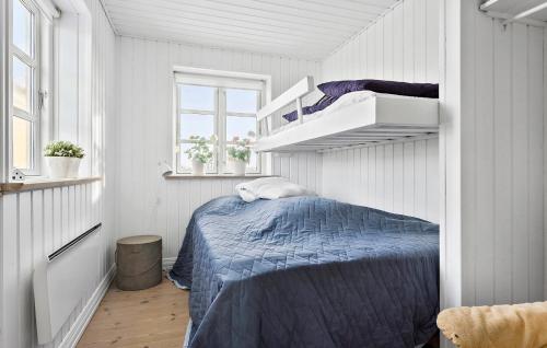 een slaapkamer met een blauw bed in een witte kamer bij Nice Home In Hjrring With Sauna in Hjørring