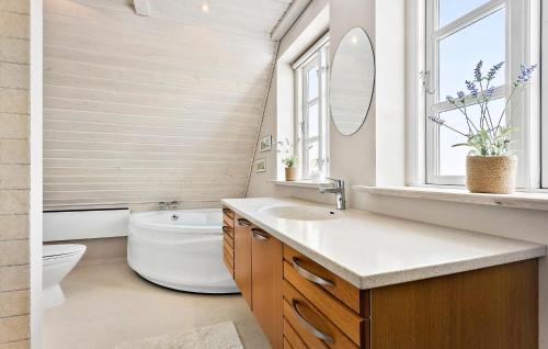 een badkamer met een wastafel, een toilet en een raam bij Nice Home In Hjrring With Sauna in Hjørring