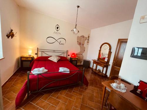 een slaapkamer met een rood bed en een spiegel bij Maremma Nel Tufo in Pitigliano