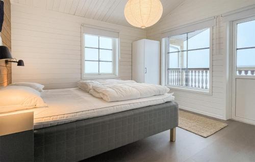 een bed in een kamer met witte muren en ramen bij Nice Apartment In Sysslebck With House A Panoramic View in Sysslebäck