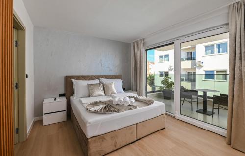 a bedroom with a large bed and a balcony at Beautiful Home In Novalja in Donji Lapac