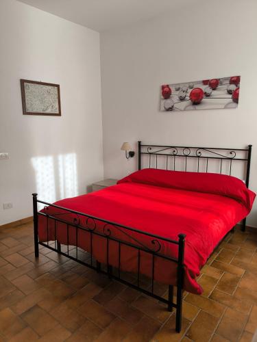 a bed with a red blanket on top of it at La Corte in Morlupo