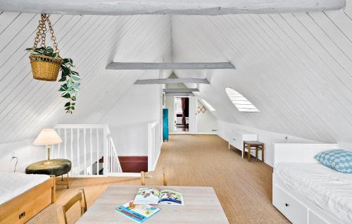 ÅkirkebyにあるBeautiful Home In Aakirkeby With Wifiの屋根裏のリビングルーム(ソファ、テーブル付)