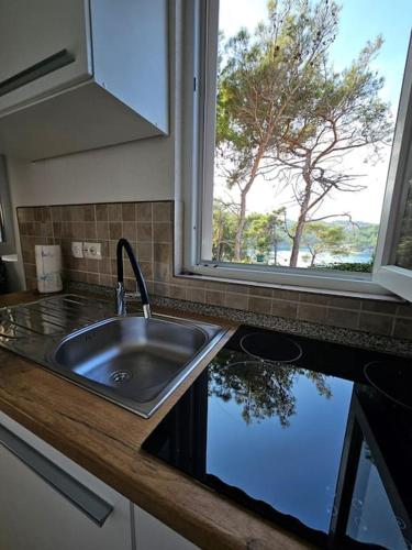 a kitchen counter with a sink and a window at Studio Dubravka in Mali Lošinj