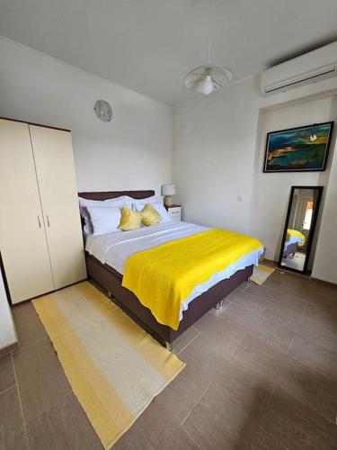 a bedroom with a large bed with a yellow blanket at Studio Dubravka in Mali Lošinj