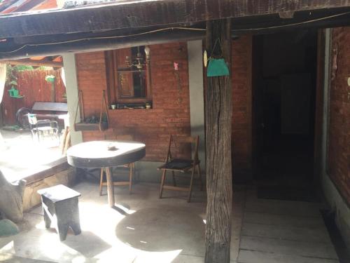 patio con mesa, sillas y pared de ladrillo en Patio olmos en Trapiche