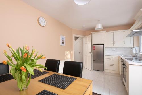 a kitchen with a table with a vase of flowers at 5 Bruach na hAbhann in Clonakilty