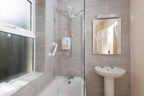 a bathroom with a shower and a sink at 5 Bruach na hAbhann in Clonakilty