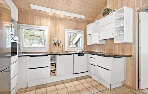 a kitchen with white cabinets and black counter tops at Awesome Home In Nørre Nebel With Sauna in Nørre Nebel