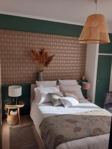 une chambre avec un grand lit avec une tête de lit verte dans l'établissement La maison de Mona, à Carcassonne