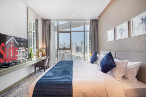 ein Hotelzimmer mit einem großen Bett und einem Schreibtisch in der Unterkunft Cosmopolitan studio full canal view by Suiteable in Dubai