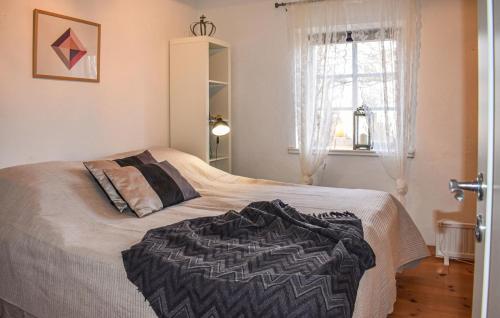 a bedroom with a bed with a black blanket on it at 1 Bedroom Nice Home In Skåne Tranås in Skåne-Tranås