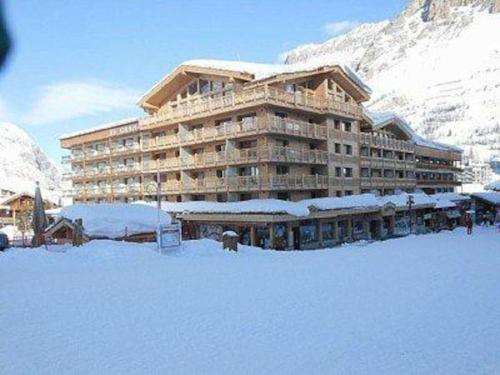 ein großes Gebäude mit Schnee davor in der Unterkunft Grand Paradis in Val dʼIsère