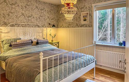 1 dormitorio con cama, ventana y lámpara de araña en Cozy Home In Linderd With Wifi, en Linderöd