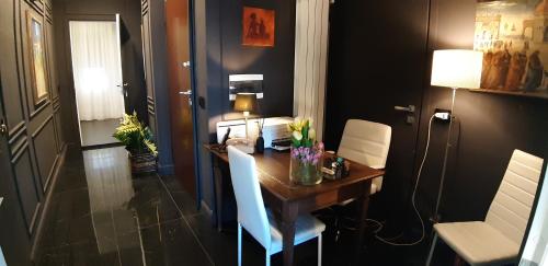 a room with a table with white chairs and a room with a bed at B&B Diamond in Reggio Calabria