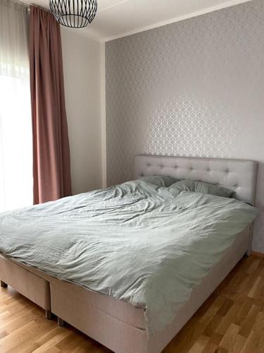 een wit bed in een slaapkamer met een raam bij Cozy one bedroom apartment in Tartu