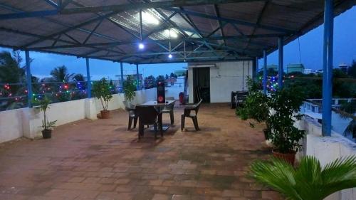 a patio with a table and chairs and lights at Visha Park International in Tirupporūr