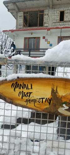 a wooden canoe on a fence in the snow at Manali Mist in Jagatsukh