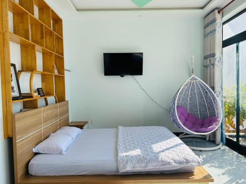 a bedroom with a bed and a swing at Lộc Vừng Homestay in Phan Thiet
