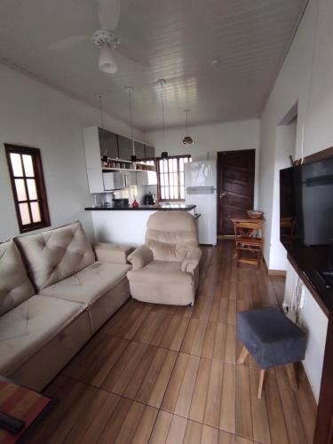 a living room with a couch and a tv at Casa 2 qtos, sendo suíte com cama Queen ar condicionado in Guapimirim