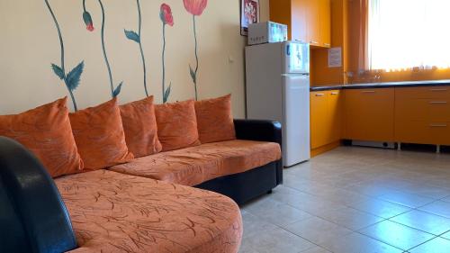 um sofá com almofadas laranja num quarto em Sunny Beach Hills Private Apartment em Sunny Beach