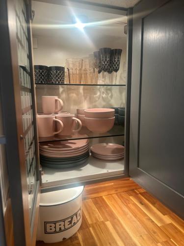 a refrigerator filled with plates and bowls and dishes at Airthrey Cottage in Bridge of Allan