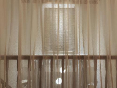 a black and white photo of a window with curtains at At corner resort & garden in Jeju