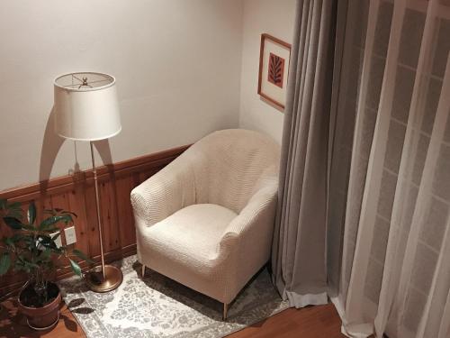 a white chair in a room with a lamp at At corner resort & garden in Jeju