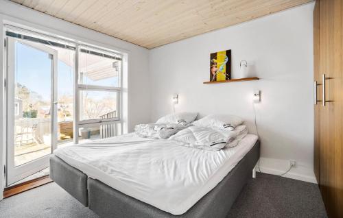 a bedroom with a large bed and a large window at Amazing Home In Sams With Wi-fi in Brundby