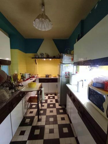 une cuisine avec une table et un réfrigérateur dans l'établissement Maison de campagne en cours de rénovation accessible en train, à Cravant