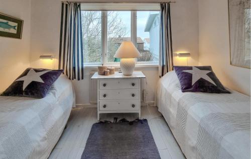 two twin beds in a room with a window at Lovely Home In Hönö With Harbor View in Hönö