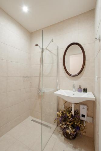 a bathroom with a shower and a sink and a mirror at Prasini Folia - Traditional Residence in Anogia