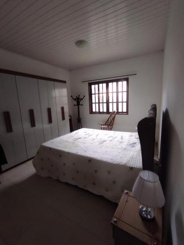 Un dormitorio con una cama grande y una ventana en Casa 2 qtos, sendo suíte com cama Queen ar condicionado, en Guapimirim