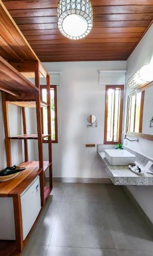 a bathroom with a sink and a large mirror at Pousada Maria Pitanga in Arraial d'Ajuda