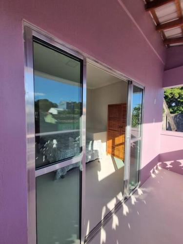uma casa roxa com uma porta de vidro e uma varanda em Apartamento Inteiro, novo, no Centro Histórico em Canavieiras