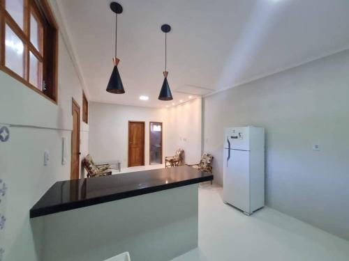uma cozinha com um balcão preto e um frigorífico em Apartamento Inteiro, novo, no Centro Histórico em Canavieiras